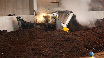 Un engin mélange des déchets végétaux déstinés à produire du biogaz pour alimenter des bus à Séquedin.&nbsp; (PHILIPPE HUGUEN / AFP)