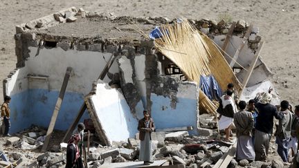 Des civils dans les d&eacute;combres d'une habitation bombard&eacute;e &agrave; Sanaa (Y&eacute;men), le 7 avril 2015. (KHALED ABDULLAH ALI AL MAHDI  / REUTERS)