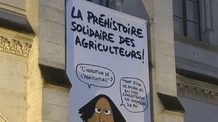 Un personnage de "Silex and the city", la BD de Jul, sur l'Hôtel de Ville d'Angoulême, apporte son soutien au mouvement des agriculteurs. (CAPTURE D'ECRAN / COMPTE X DU FESTIVAL D'ANGOULÊME)