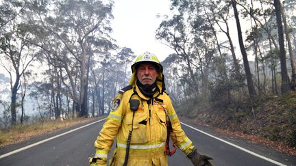 Un pompier surveille les&nbsp;feux de brousse près de la zone résidentielle de Dargan, à 120 kilomètres au nord-ouest de Sydney.&nbsp; (SAEED KHAN / AFP)