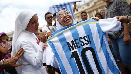 Des religieuses attendent le pape Fran&ccedil;ois en brandissant le maillot de football du joueur argentin Lionel Messi sur la place Saint-Pierre (Vatican), le 13 juillet 2014. (TONY GENTILE / REUTERS)