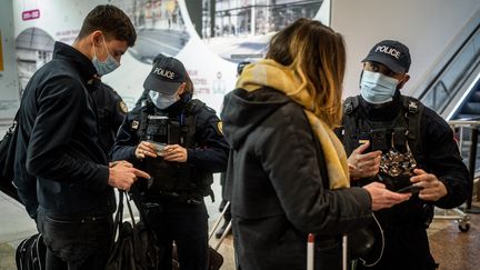 Des policiers contrôlent des attestations de déplacement, le 27 mars 2021, à Lyon. (NICOLAS LIPONNE / HANS LUCAS / AFP)