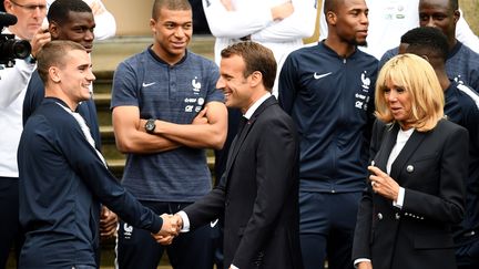 Emmanuel Macron serre la main d'Antoine Griezmann, le 5 juin 2018, à Clairefontaine (Yvelines). (FRANCK FIFE / AFP)