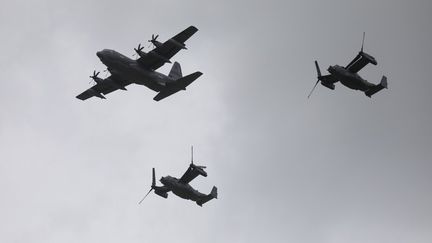 Un avion américain Lockheed C-130 Hercules et des Boeing-Bell V-22 Osprey survolent Carentan, en Normandie,&nbsp;le 5 juin 2019, dans le cadre des commémorations du Débarquement.&nbsp; (LUDOVIC MARIN / AFP)