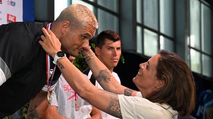 Laure Manaudou remet la médaille de champion de France 2023 du  50m nage libre à Florent Manaudou. (DAMIEN MEYER / AFP)