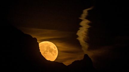 La "super lune" se découvre derrière les montagnes des Alpes, à&nbsp;Chexbres (Suisse). (FABRICE COFFRINI / AFP)