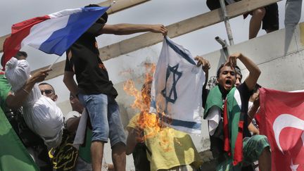 Des manifestants ont br&ucirc;l&eacute; des drapeaux isra&eacute;liens et brandit des panneaux "sionisme = nazisme". ( PHILIPPE WOJAZER / REUTERS)