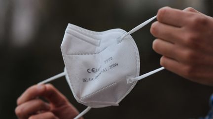 Une femme tient&nbsp;un masque FFP2 à L'Aquila (Italie), le 28 décembre 2021. (LORENZO DI COLA / NURPHOTO)