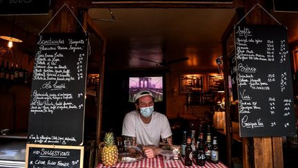 Un barman qui propose des boissons à emporter, à Paris, le 9 mai 2020. (CHRISTOPHE ARCHAMBAULT / AFP)