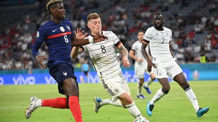 Paul Pogba et Toni Kroos à la lutte lors de France-Allemagne. (FEDERICO GAMBARINI / DPA)