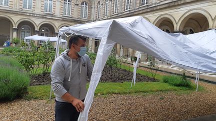 Un&nbsp;agent technique monte des tentes en vue des visites familiales dans le cloître de l'Ehpad de l'Ordre de Malte, le 4 juin 2020 à Clamart (Hauts-de-Seine). (SOLENNE LE HEN / RADIO FRANCE)