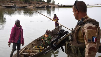 Un soldat français de l'opération Barkhane au port de Korioumé à Tombouctou, avec des habitants de la ville. Photo prise le 9 mars 2016. (PASCAL GUYOT / AFP)