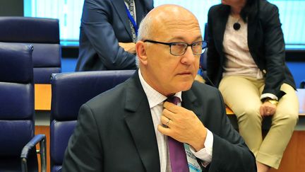 Le ministre des Finances, Michel Sapin, ajuste son n&oelig;ud de cravate le 19 juin 2014 lors d'un sommet europ&eacute;en &agrave; Luxembourg. (GEORGES GOBET / AFP)