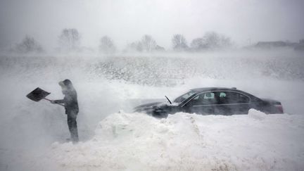 Une femme tente de d&eacute;senliser sa voiture lors d'une temp&ecirc;te de neige &agrave; Portland (Maine), le 9 f&eacute;vrier 2013. (ROBERT F. BUKATY / AP / SIPA)