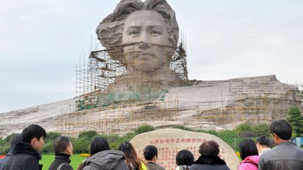 Des touristes chinois observent une statue de Mao Ts&eacute;-toung&nbsp;en construction &agrave; Changsha (Chine), le 26 novembre 2013. (AFP)