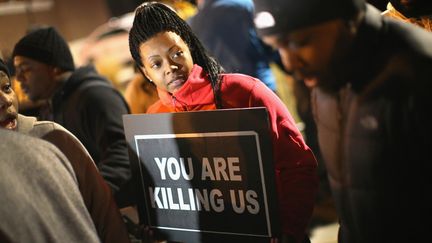 Une femme manifeste contre les violences polici&egrave;res, le 24 novembre 2014, devant le commissariat de Ferguson (Missouri). (SCOTT OLSON / GETTY IMAGES NORTH AMERICA / AFP )