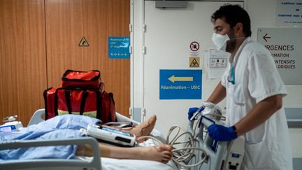 Un soignant s'occupe d'un patient atteint du Covid-19, le 21 janvier 2022, dans une unité de soins intensifs de l'hôpital Saint-Luc à Lyon. (NICOLAS LIPONNE / HANS LUCAS / AFP)