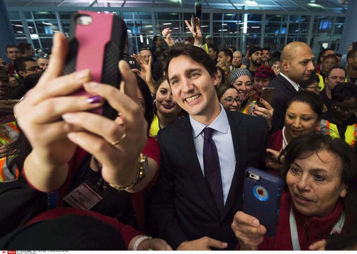 Le Premier ministre canadien Justin Trudeau prend des selfies avec des réfugiés syriens arrivés à Toronto (Canada), le 10 décembre 2015. (NATHAN DENETTE / AP / SIPA)