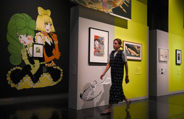 Une visiteuse passe devant l'œuvre Princess Jellyfish d'Higashimura Akiko (à gauche) durant une présentation à la presse de l'exposition Manga, au British Museum, à Londres, le 22 mai 2019 (DANIEL LEAL-OLIVAS / AFP)