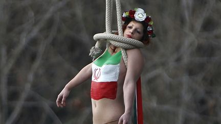 Une activiste des Femen simule une pendaison depuis un pont, à Paris, le 28 janvier 2016.&nbsp; (CHARLES PLATIAU / REUTERS)