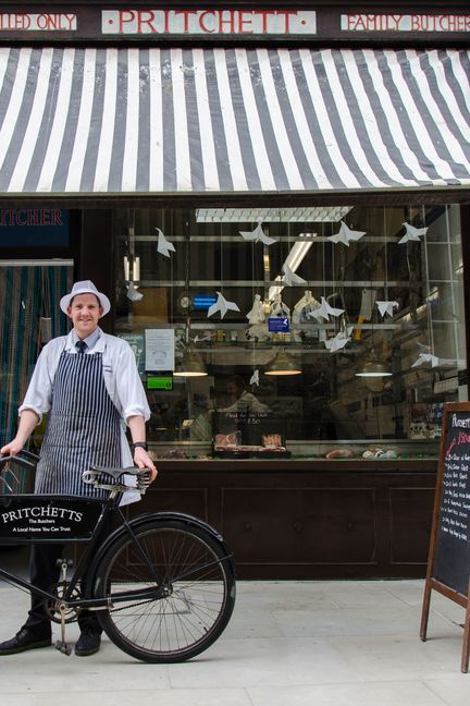 Charles Aldridge pose devant la boucherie familiale, ornée de colombes en papier, à Salisbury, le 16 mai 2018. (YANN THOMPSON / FRANCEINFO)