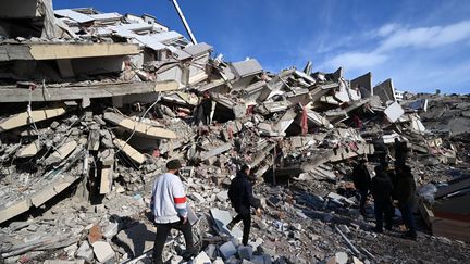 Des personnes marchent au milieu des décombres à Kahramanmaras (Turquie) le 8 février 2023, après un violent séisme. (OZAN KOSE / AFP)