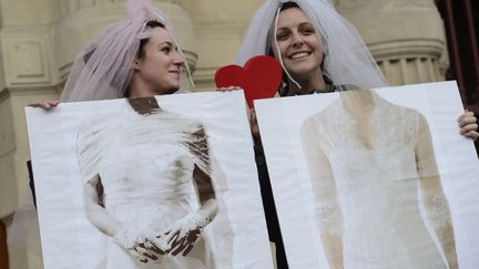 Des jeunes femmes c&eacute;l&egrave;brent le vote du projet de loi autorisant le mariage pour les personnes de m&ecirc;me sexe, devant la mairie de Paris, le 23 avril 2013. (BERTRAND GUAY / AFP)