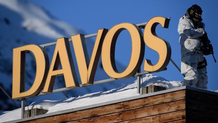 Un policier en tenue de camouflage sur un toit pendant le Forum économique où sont réunis 120 pays et 53 Chefs d'État à Davos (Suisse), le 20 janvier 2020. (FABRICE COFFRINI / AFP)