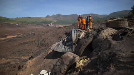 Des pompiers s'affairent dans les décombres du barrage de Brumadinho (Brésil), le 31 janvier 2019. (MAURO PIMENTEL / AFP)