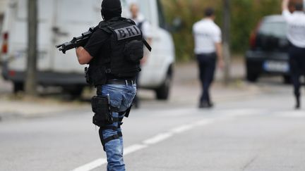 Un policier de la BRI à Saint-Étienne-du-Rouvray  (Seine-Maritime), le 26 juillet 2016, après le meurtre du prêtre Jacques Hamel. (CHARLY TRIBALLEAU / AFP)