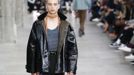 Chez Lanvin, Lucas Ossendrijver a imaginé une collection dédiée au travail de la main : "j'ai pris le parti de la générosité et de la créativité. Cette collection ne parle pas d'un unique concept mais de l'idée d'un collage, fait de possibilités différentes. C'est une histoire de liberté", confie-t-il. Des cordes s'attachent à la ceinture, des bandes et des sangles ponctuent les silhouettes romantiques imaginées par le créateur. La collection s'inspire du vestiaire urbain avec ces pantalons d'ouvriers aux revers raccourcis, les lacets colorés ou son blouson en cuir.  
 (PATRICK KOVARIK / AFP)