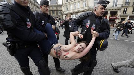 En marge du d&eacute;fil&eacute; du Front national, aux abords de la place de l'Op&eacute;ra, &agrave; Paris, des Femen ont protest&eacute; et ont aussit&ocirc;t &eacute;t&eacute; interpell&eacute;es par les forces de l'ordre. (KENZO TRIBOUILLARD / AFP)