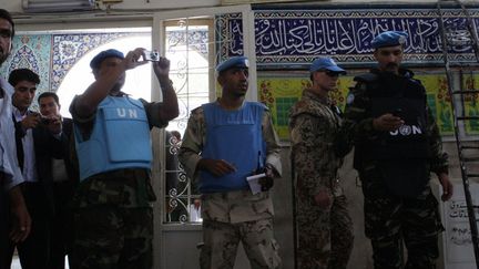 Des observateurs de l'ONU prennent des photos apr&egrave;s un attentat-suicide &agrave; Damas, en Syrie, le 14 juin 2012. (LOUAI BESHARA / AFP)