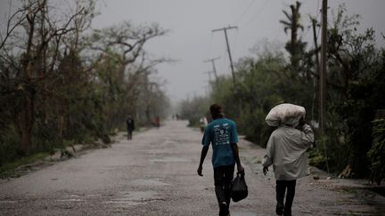 Des habitants de Cayes (Haïti) longent la route après le passage de l'ouragan, le 4 octobre 2016 (ANDRES MARTINEZ CASARES / REUTERS)