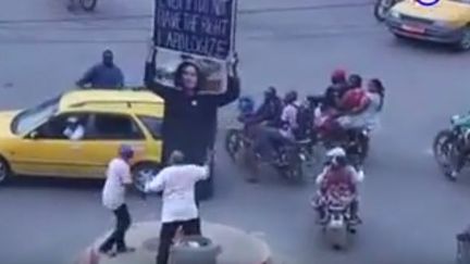 Des activistes renversent une installation artistique de la Française Sylvie Blocher à Douala (Cameroun), le 7 décembre 2017. (Capture d&#039;écran Youtube)