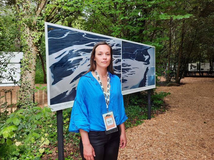 La photographe Mélanie Wenger devant ses&nbsp; photos du glacier Ampère, août&nbsp;2022 (ANNE CHEPEAU / FRANCEINFO / RADIO FRANCE)