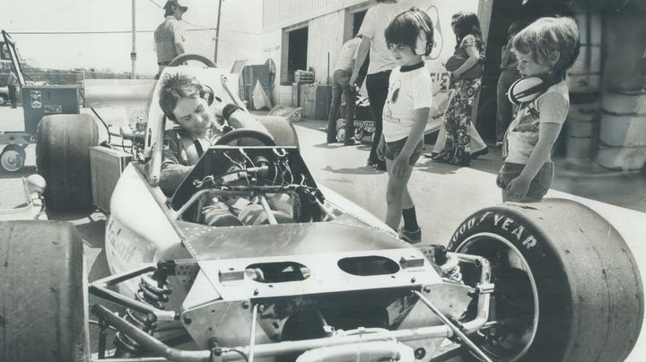 Gilles Villeneuve teste le baquet de sa voiture sous les yeux de son fils Jacques (avec le t-shirt Snoopy au centre), le 20 mai 1977 sur le circuit de&nbsp;Mosport (Canada). (JOHN MAHLER / GETTY IMAGES)