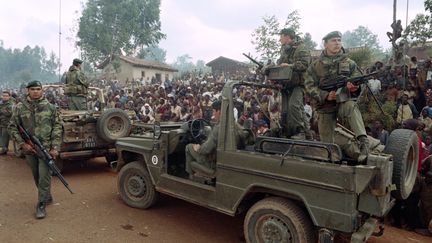 Des Rwandais hutus accueillent un détachement de&nbsp;militaires français dans un camp de réfugiés à Butare (Rwanda), le 3 juillet 1994. (HOCINE ZAOURAR / AFP)