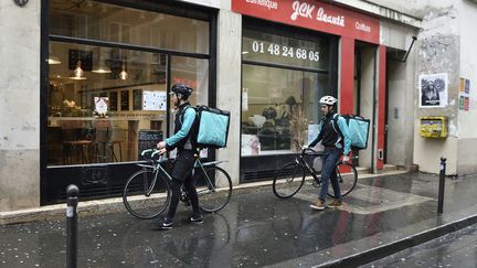 Deux livreurs de l'entreprise Deliveroo, à Paris, le 31 mars 2016. (ERIC FEFERBERG / AFP)