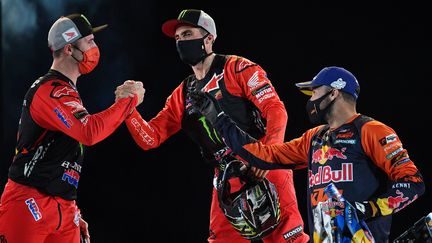 Kevin Benavídes, Ricky Brabec et Sam Sunderland se félicitent à l'issue du Dakar en janvier 2021 en Arabie Saoudite. (FRANCK FIFE / AFP)