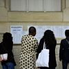 Des professeurs et des élèves regardent les résultats du baccalauréat au lycée Voltaire à Paris, le 4 juillet 2023. (JULIEN DE ROSA / AFP)