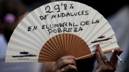 Sur cet &eacute;ventail, cette femme d&eacute;nonce que "29,8 Andalous vivent sous le seuil de pauvret&eacute;". (CRISTINA QUICLER / AFP)