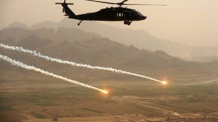 Un hélicoptère américain Blackhawk au-dessus du sud-Afghanistan, alors que des tirs visent des cibles le 25 mars 2011 (AFP/PETER PARKS)