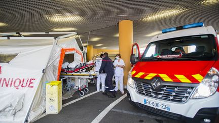 Un malade du Covid-19 sur un brancard est installé dans une tente de triage des patients devant le CHU de Fort-de-France, en Martinique, le 30 juillet 2021. (LIONEL CHAMOISEAU / AFP)