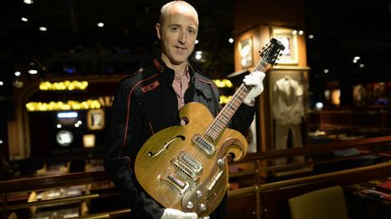 La guitare de John Lennon pr&eacute;sent&eacute;e, le 13 mai 2013 par Martin Nolan, directeur ex&eacute;cutif de Julien's Auction's, la maison charg&eacute;e de la vente aux ench&egrave;res &agrave; New York.&nbsp; (TIMOTHY CLARY / AFP)