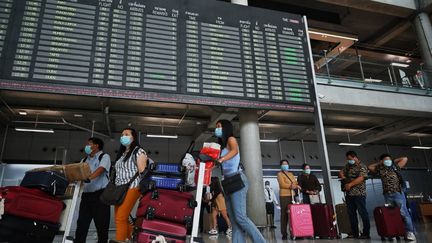 Des voyageurs marchent dans l'aéroport international de Suvarnabhumi, à Bangkok (Thaïlande), le 1er juillet 2022.&nbsp; (LILLIAN SUWANRUMPHA / AFP)