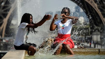Des personnes se rafraîchissent à la fontaine du Trocadéro, à Paris, le 25 juillet 2018.&nbsp; (BERTRAND GUAY / AFP)