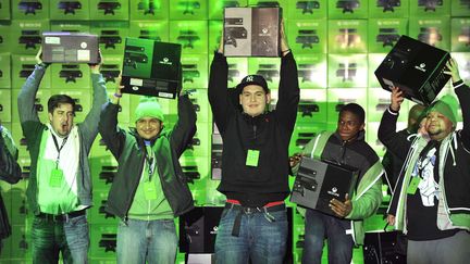 Les premiers acheteurs de la console Xbox One de Microsoft brandissent leur troph&eacute;e au magasin Best Buy de Times Square &agrave; New York (Etats-Unis), le 22 novembre 2013. (CHARLES SYKES / AP / SIPA)