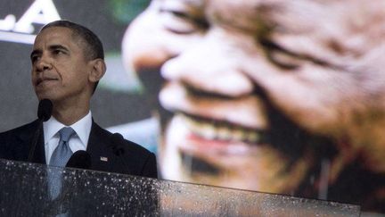 Barack Obama prend la parole devant un portrait géant du président défunt Nelson Mandela le 10 décembre 2013 à Johannesburg. (Photo/AFP: Brendan Smialowski)