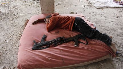 Un soldat de l'arm&eacute;e syrienne libre se repose &agrave; Alep (Syrie), le 2 d&eacute;cembre 2013. (MOLHEM BARAKAT / REUTERS)